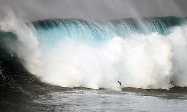A huge wave and a tiny surfer.