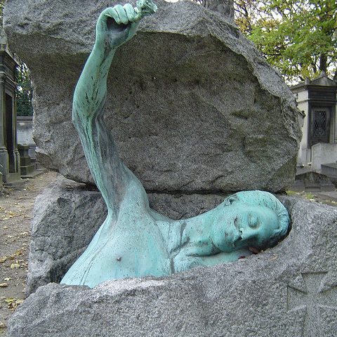 gravestone with statue coming out of grave