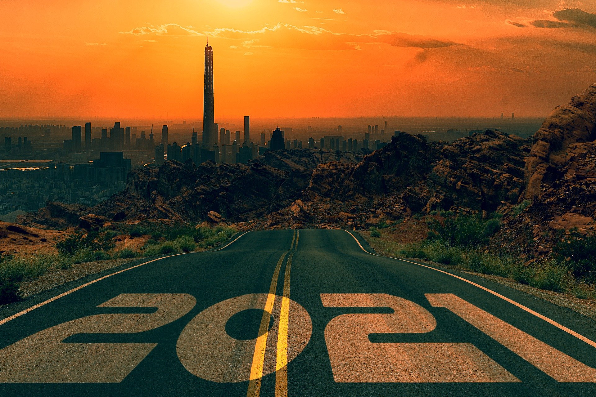 A road leading to a city with 2021 written on the lanes