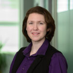 Headshot of Gretyl Kinsey: White woman with shorter brown hair, purple shirt with black vest.