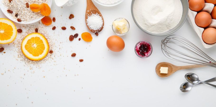 Cooking ingredients including sugar, flour, spices, and eggs laid out on a counter