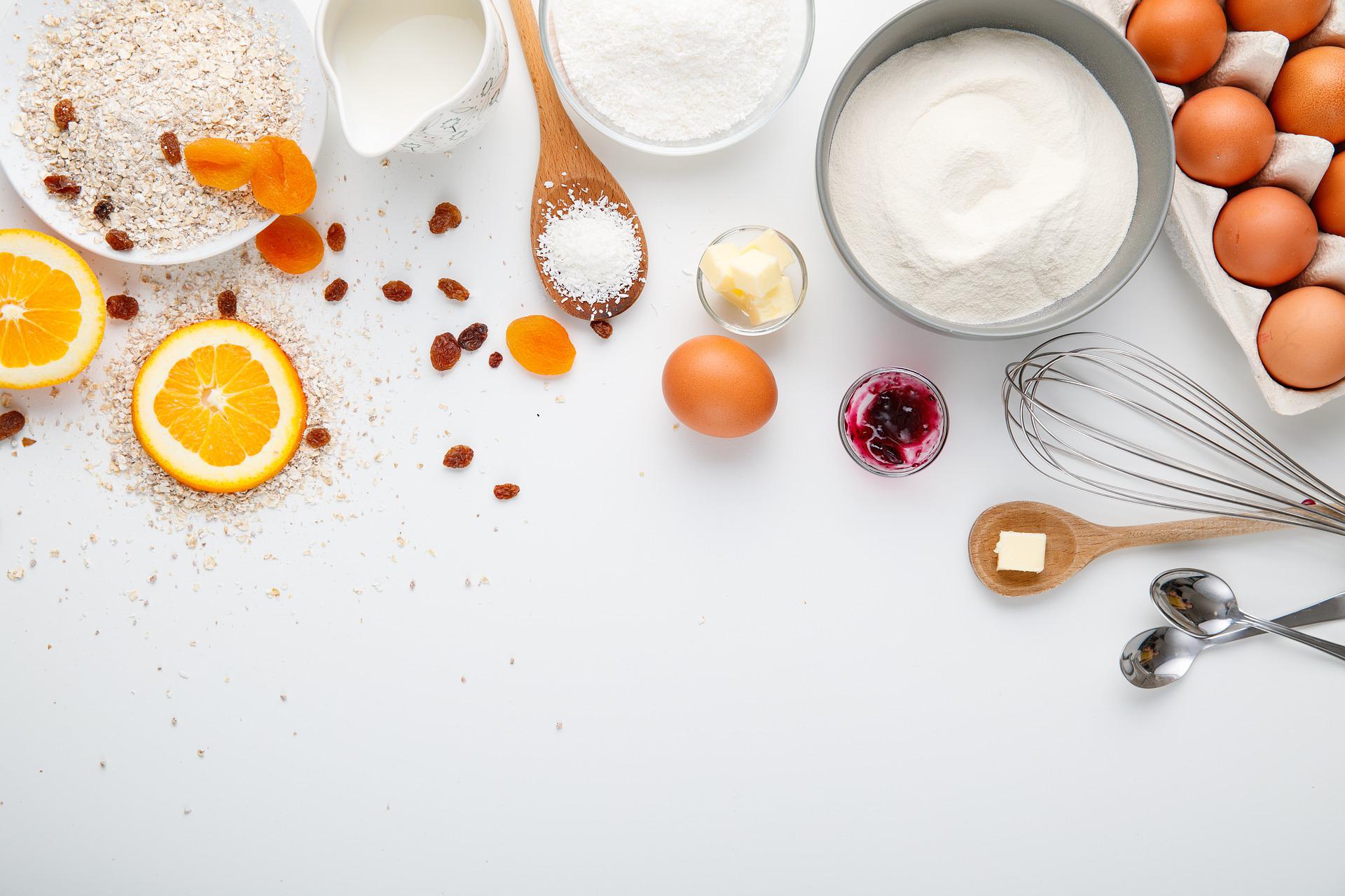 Cooking ingredients including sugar, flour, spices, and eggs laid out on a counter