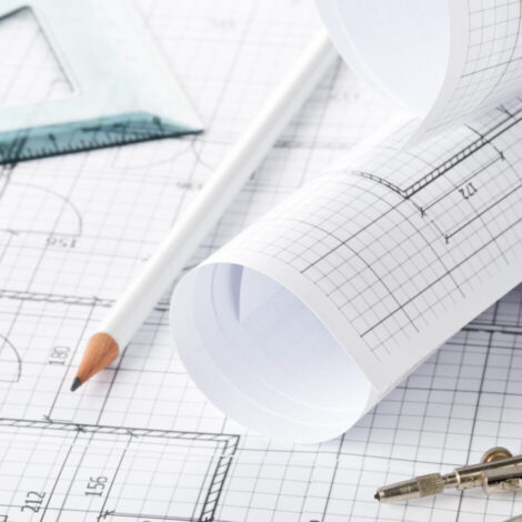 Rolls of architectural blueprint house building plans on blueprint background on table with pencil, square and compasses