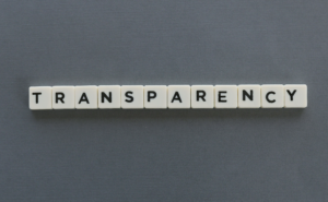 grey background with Scrabble game tiles spelling "TRANSPARENCY"
