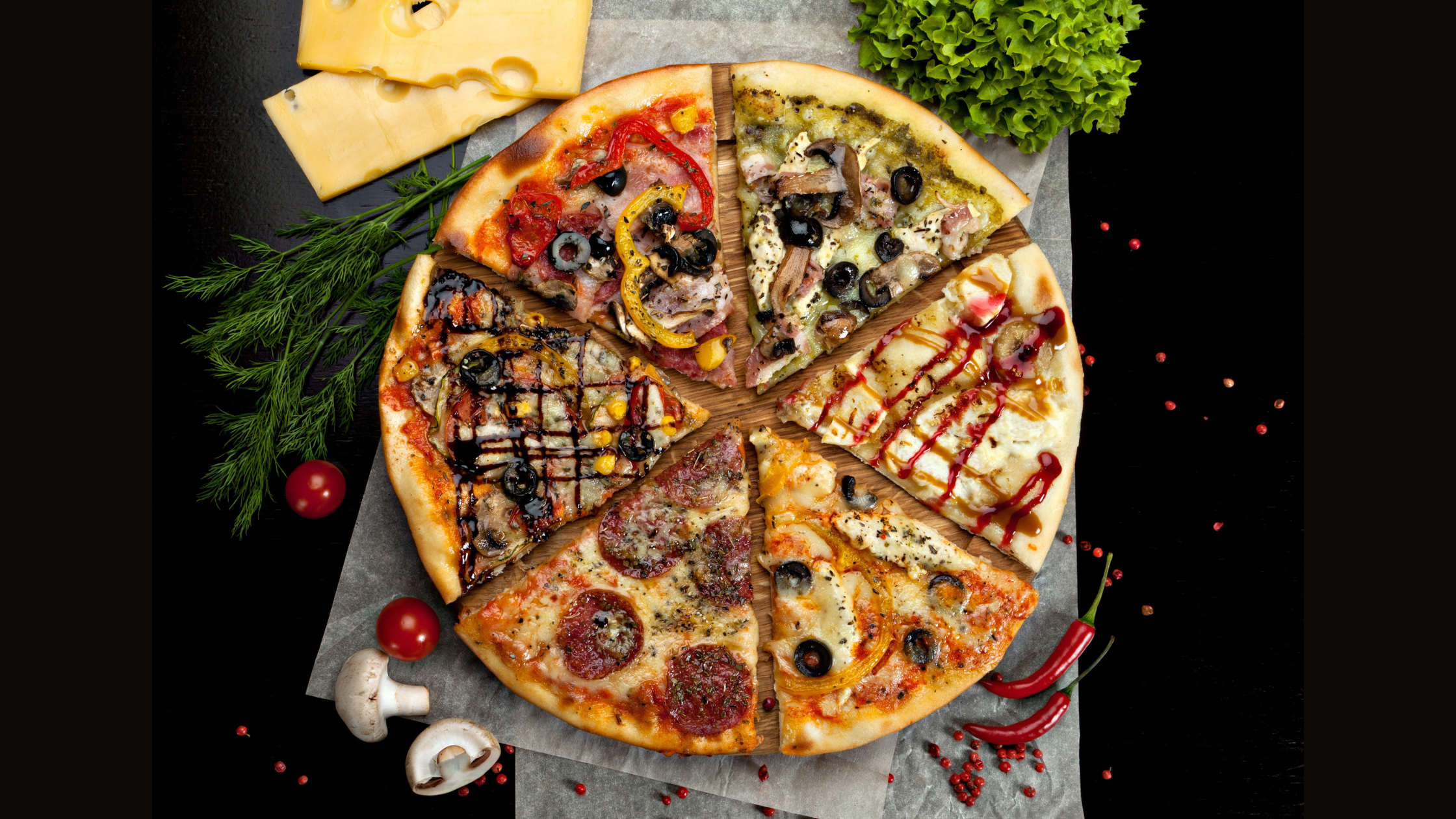 six slices of pizza with a wide variety of different toppings on each piece, arranged in a circle like a regular pizza. The pizza is on a wooden board on black background
