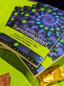 Green table with a stack of blue books on top. Title says, "Content transformation: An introduction to Enterprise Content Ops and content strategy."