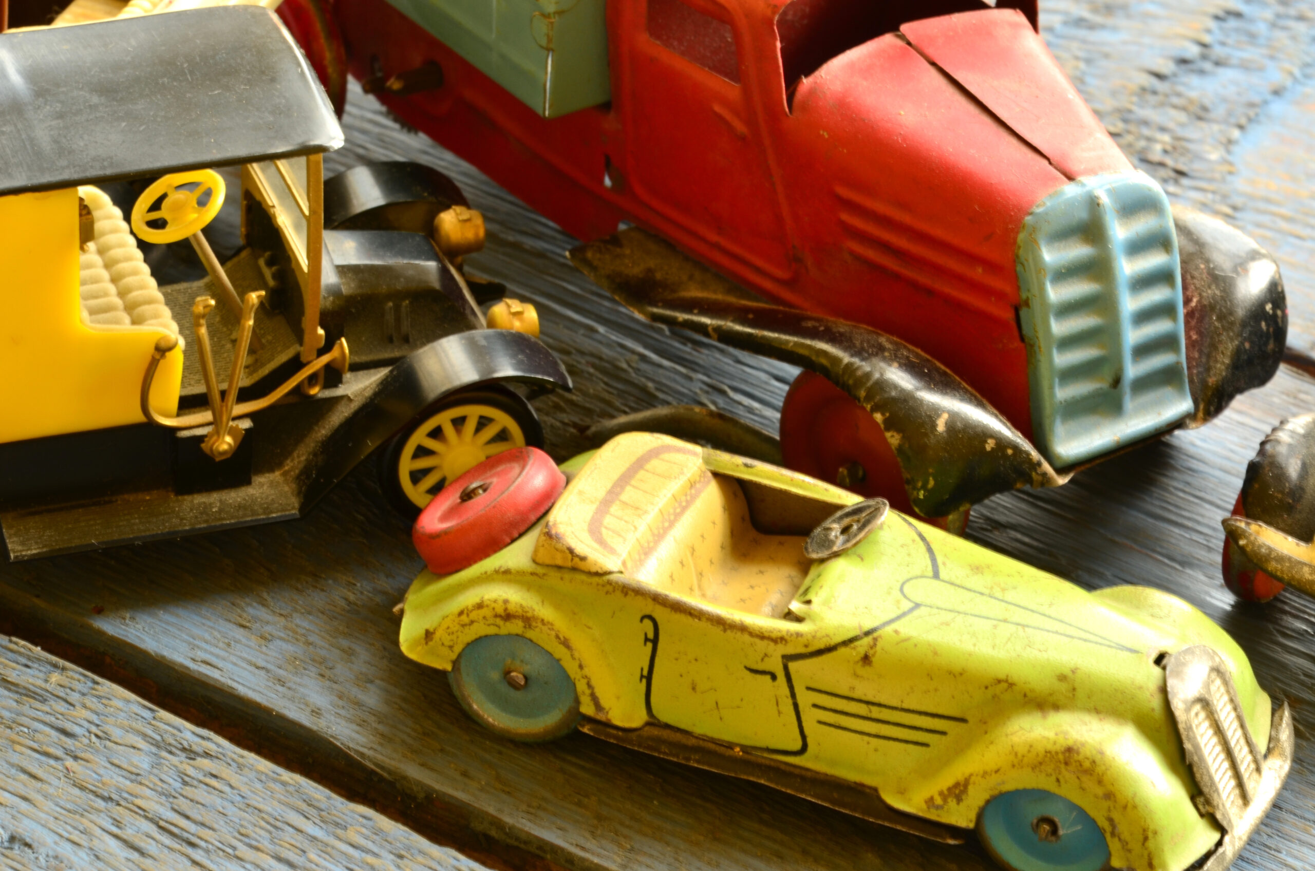 Set of vintage toys - convertible toy car, trucks (lorries) toy, post car toy, yellow car looks similar to a Ford Model T