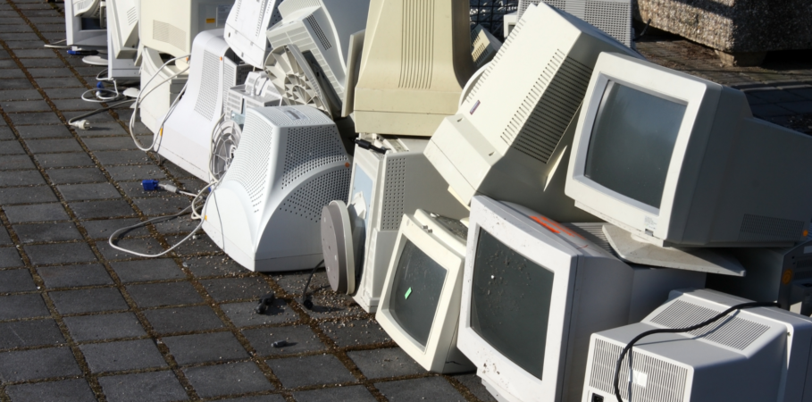 pile of outdated computer hardware outside in the sun, communicating a build up of technical debt