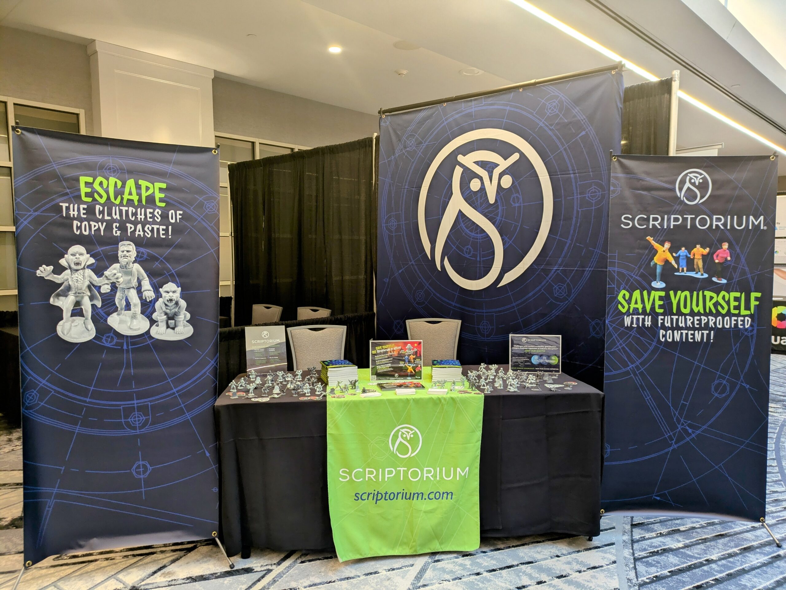 Booth with green and blue banners and horror theme swag. The left banner says, "Escape the clutches of copy & paste," and the right banner says, "Save yourself with futureproof content operations." 